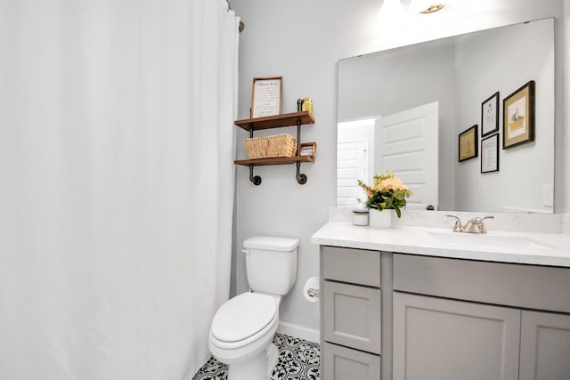 bathroom with toilet, baseboards, and vanity