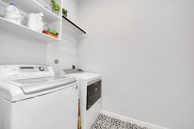 washroom featuring laundry area, washing machine and dryer, and baseboards