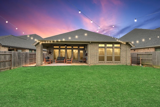 rear view of property with a yard, a fenced backyard, and a patio area