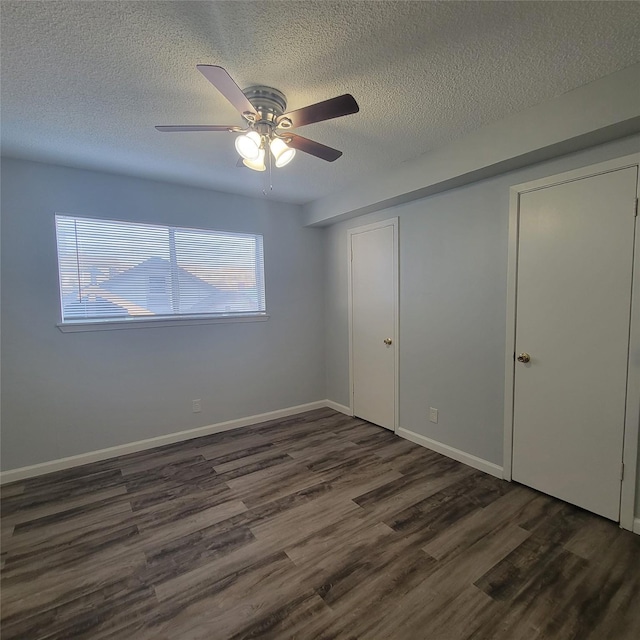 unfurnished bedroom with a ceiling fan, dark wood-style flooring, a textured ceiling, baseboards, and a closet