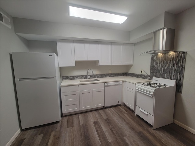 kitchen with visible vents, white appliances, dark wood-style floors, wall chimney range hood, and a sink