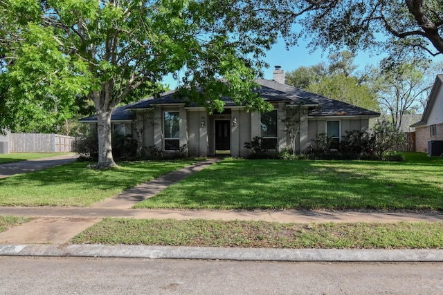 single story home featuring fence, central air condition unit, a chimney, and a front lawn