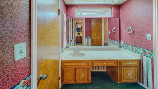 bathroom with vanity and wallpapered walls