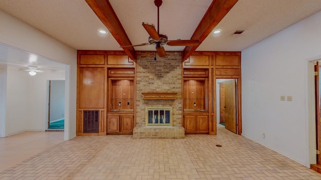 unfurnished living room with a ceiling fan, brick patterned floor, and beam ceiling