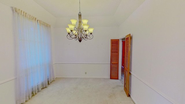 carpeted empty room with plenty of natural light and a notable chandelier