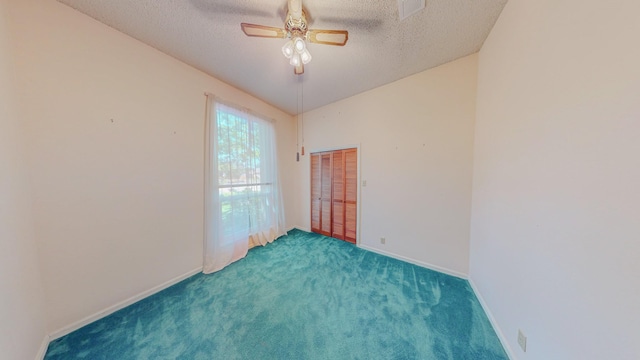 empty room featuring carpet flooring, a textured ceiling, a ceiling fan, baseboards, and visible vents