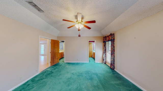 empty room featuring a textured ceiling, carpet, a ceiling fan, baseboards, and visible vents
