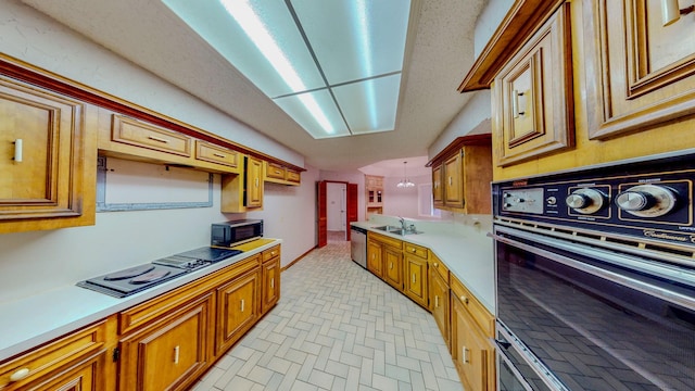 kitchen with light countertops, brown cabinetry, black appliances, and brick patterned floor