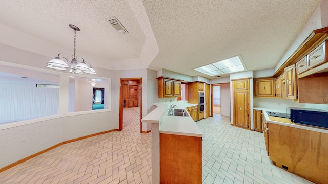 kitchen with visible vents, brown cabinetry, baseboards, light countertops, and a sink