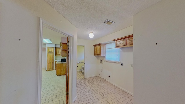 laundry room with washer hookup, electric dryer hookup, visible vents, cabinet space, and brick patterned floor