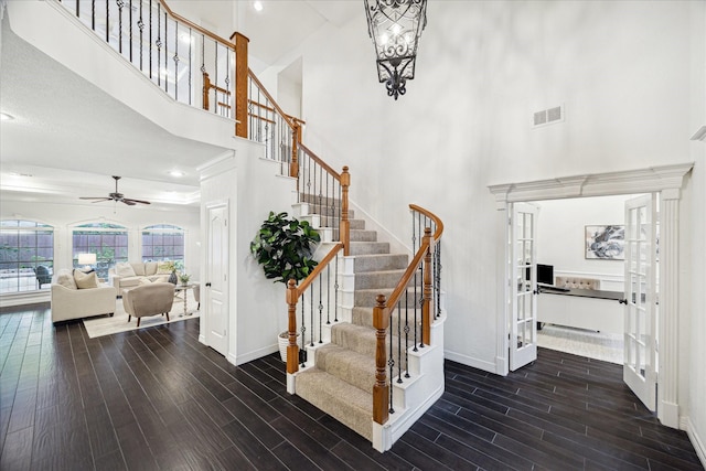 staircase featuring baseboards, visible vents, and wood finished floors