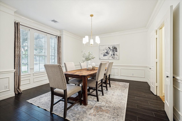 dining room featuring visible vents, dark wood-style flooring, a decorative wall, and a chandelier