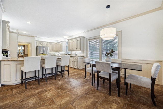 dining area with recessed lighting, ornamental molding, wainscoting, and stone finish floor