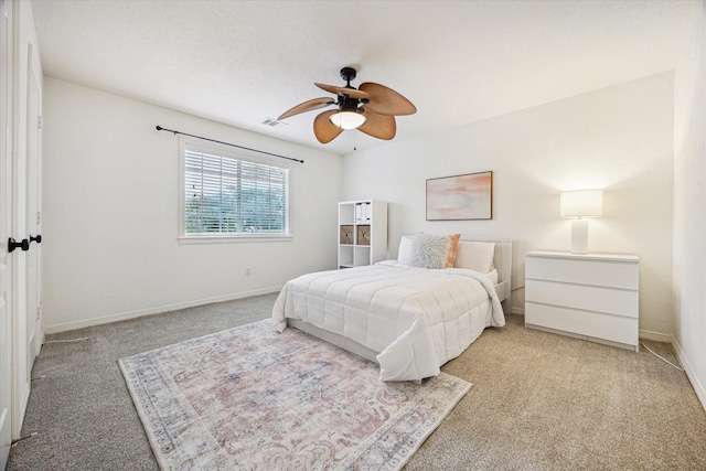 carpeted bedroom with baseboards, a ceiling fan, and visible vents