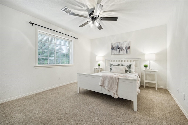 carpeted bedroom with visible vents, a ceiling fan, and baseboards