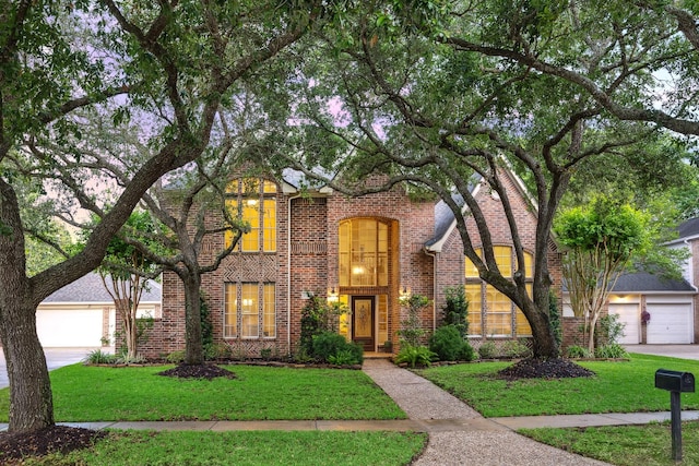traditional home with brick siding, a garage, and a front lawn