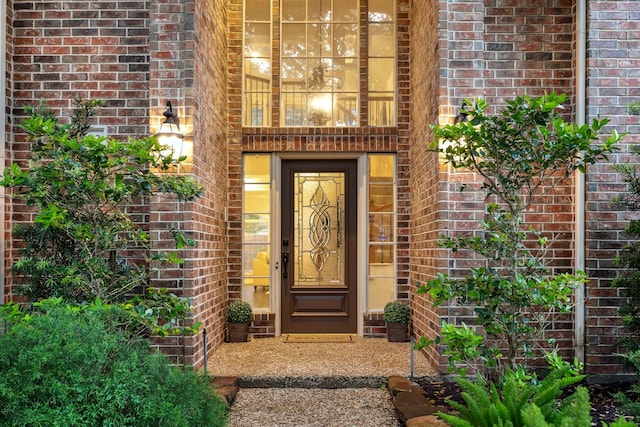 view of exterior entry featuring brick siding