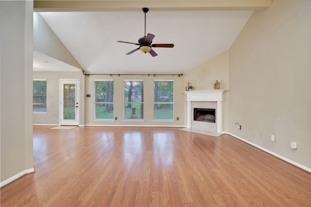 unfurnished living room featuring baseboards, a ceiling fan, a premium fireplace, and light wood-type flooring