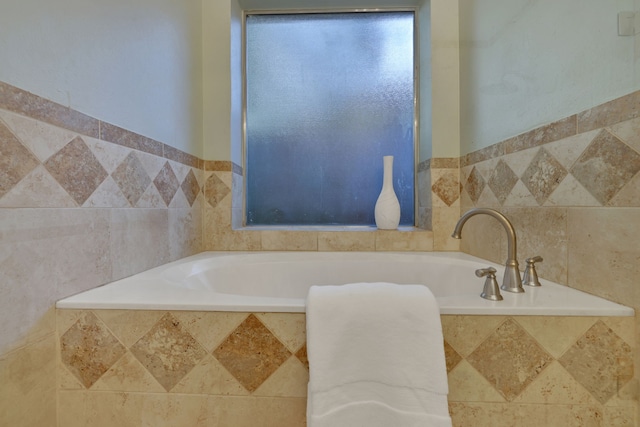 full bathroom with a garden tub and tile walls