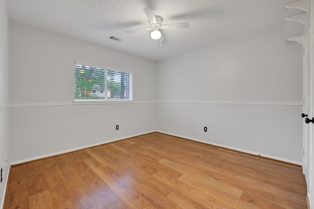 unfurnished room featuring light wood-style floors, baseboards, ceiling fan, and visible vents