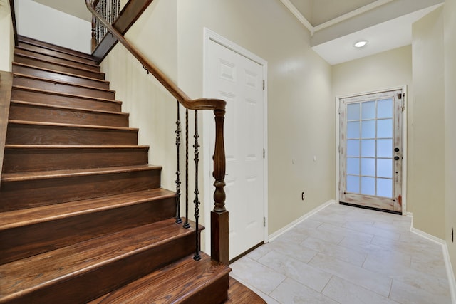 foyer featuring baseboards, stairs, and light tile patterned flooring