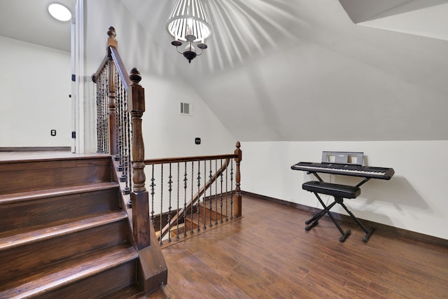 interior space featuring vaulted ceiling, visible vents, baseboards, and hardwood / wood-style flooring