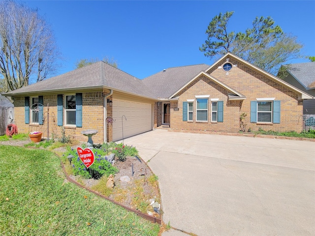 ranch-style house with brick siding, a front lawn, concrete driveway, an attached garage, and a shingled roof