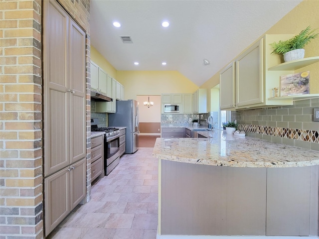 kitchen featuring a peninsula, recessed lighting, tasteful backsplash, a sink, and stainless steel appliances