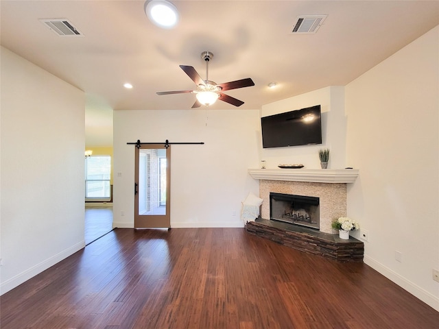 unfurnished living room with visible vents, baseboards, wood finished floors, and a fireplace