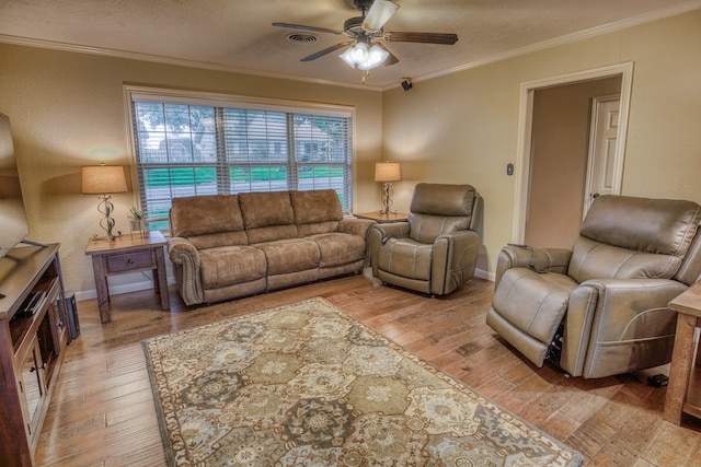 living room with baseboards, ornamental molding, light wood-style flooring, and ceiling fan