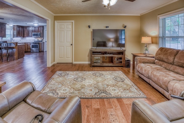 1302 Woodson Ln, Brenham, TX 77833 - living area featuring hardwood / wood-style floors, a ceiling fan, crown molding, baseboards, and a textured ceiling