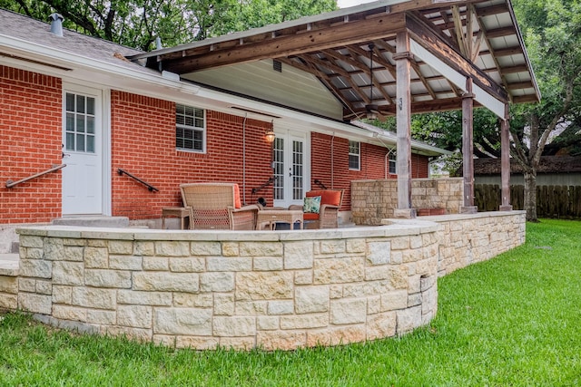 view of patio / terrace with a ceiling fan, fence, and french doors