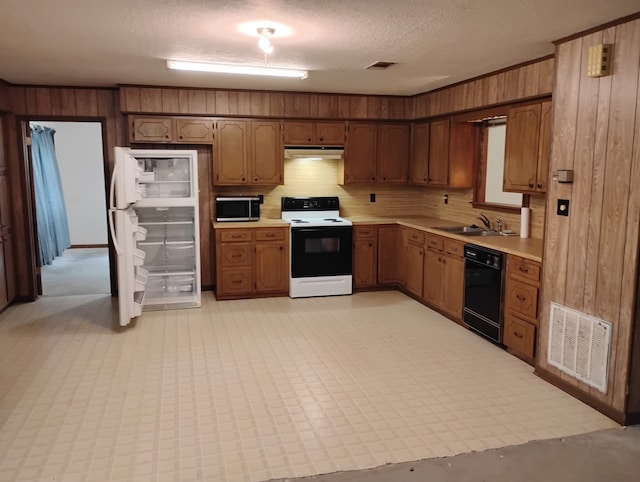 169 Lakeview Pnes, Livingston, TX 77351 - kitchen with electric range oven, black dishwasher, stainless steel microwave, light countertops, and wooden walls