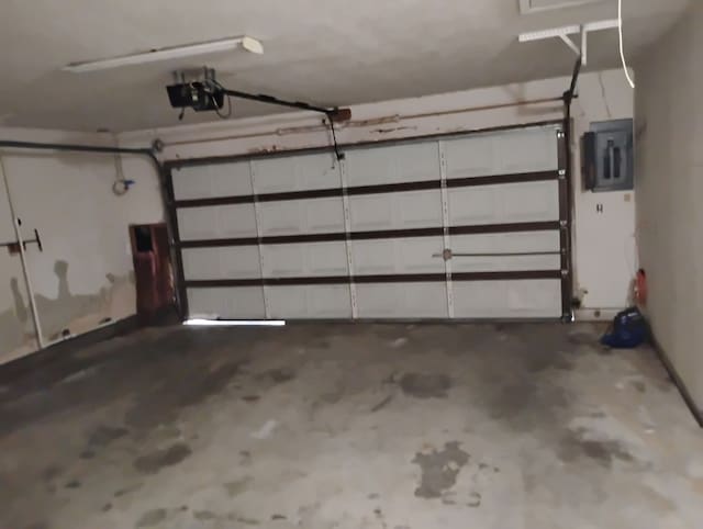garage with a garage door opener and electric panel