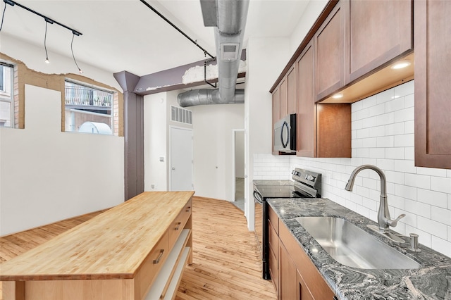 kitchen featuring a sink, range with electric cooktop, tasteful backsplash, visible vents, and butcher block counters