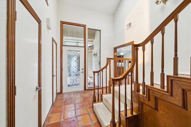 entryway featuring visible vents, a ceiling fan, light tile patterned floors, and stairway