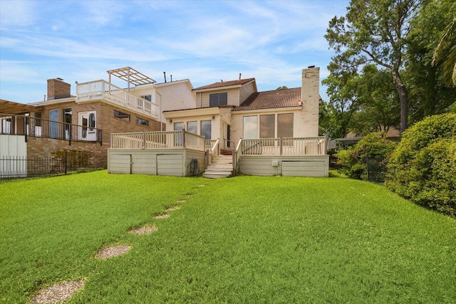 back of house with a lawn, fence, a chimney, and a deck