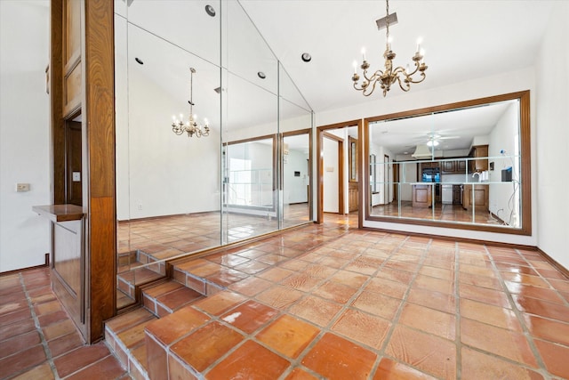 interior space with high vaulted ceiling, ceiling fan with notable chandelier, and stone tile flooring