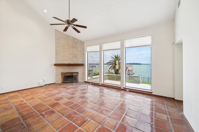 unfurnished living room featuring visible vents, a ceiling fan, a brick fireplace, and tile patterned floors