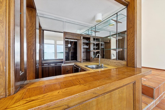 bar with a sink, wet bar, and a textured ceiling