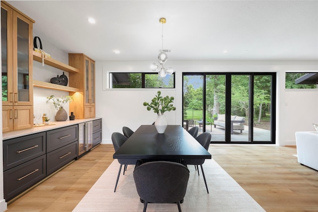 dining room with recessed lighting, light wood-type flooring, and a chandelier
