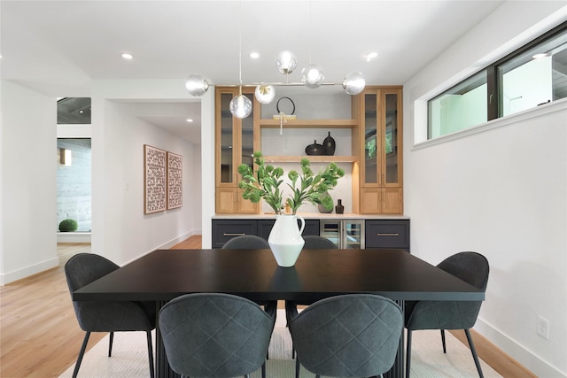 dining room with light wood-type flooring, recessed lighting, and baseboards