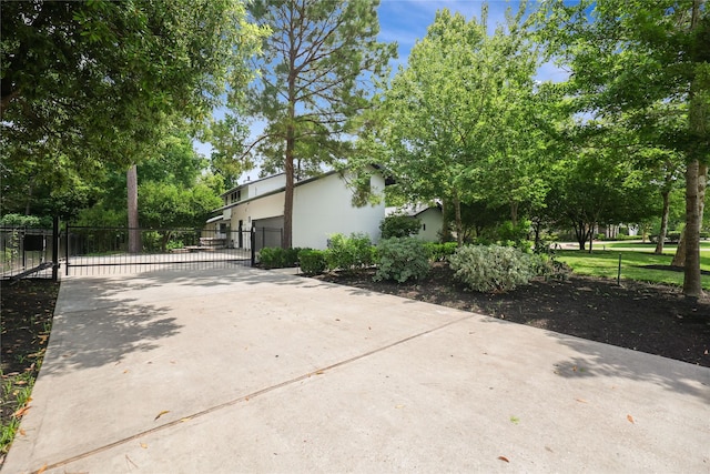 view of home's exterior featuring fence, a gate, stucco siding, and driveway
