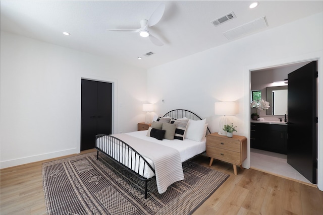 bedroom with light wood finished floors and visible vents