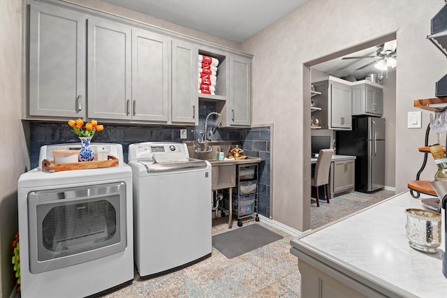 clothes washing area featuring a ceiling fan, cabinet space, and washer and dryer