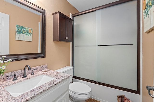 bathroom featuring vanity, toilet, and shower / bath combination with glass door