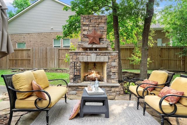 view of patio / terrace featuring an outdoor stone fireplace and a fenced backyard