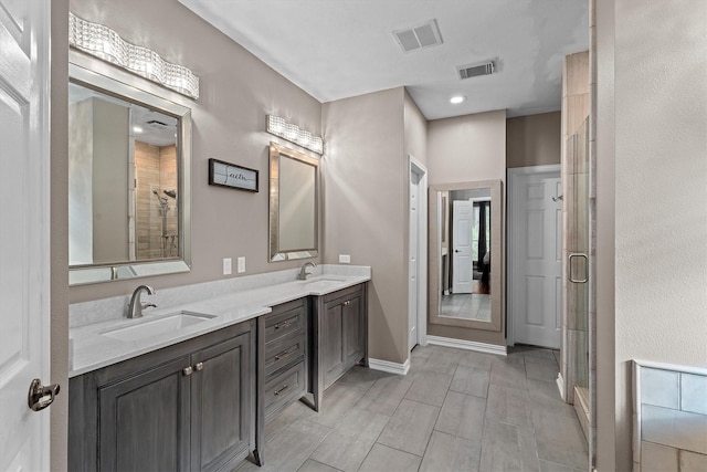 bathroom with visible vents, a sink, and a shower stall