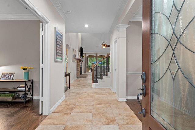 foyer featuring crown molding, baseboards, stairway, arched walkways, and a ceiling fan
