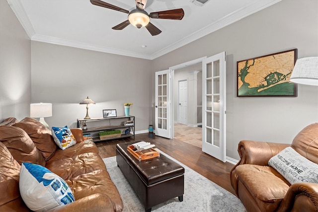 living area featuring french doors, crown molding, wood finished floors, and ceiling fan